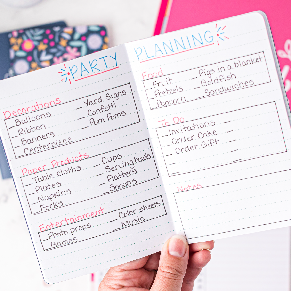 A mini notebook open to a spread with party planning notes.