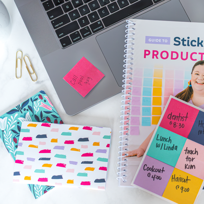 Colorful mini notebook with sticky notes and a laptop on a desk