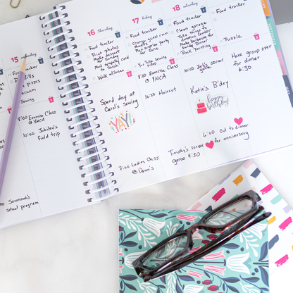 Open planner with daily tasks and a pair of glasses on a colorful mini notebook