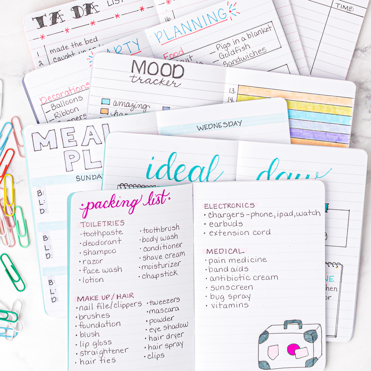Collection of mini notebooks with various lists and notes on a white background