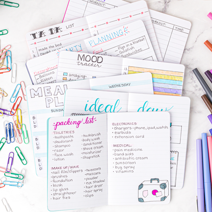 Collection of open mini notebooks with various notes and charts written in them. 