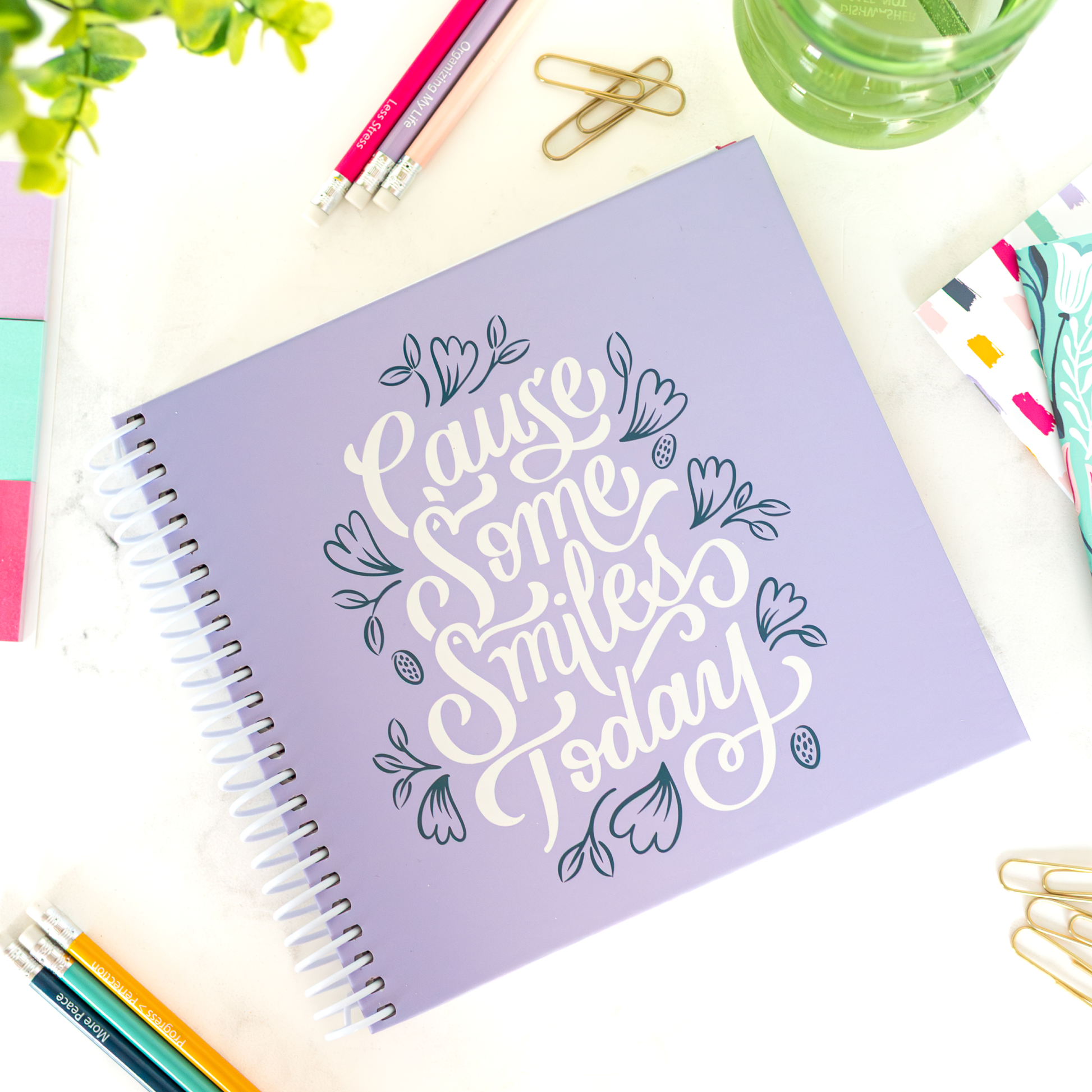 Purple planner with decorative text on a desk with stationery items