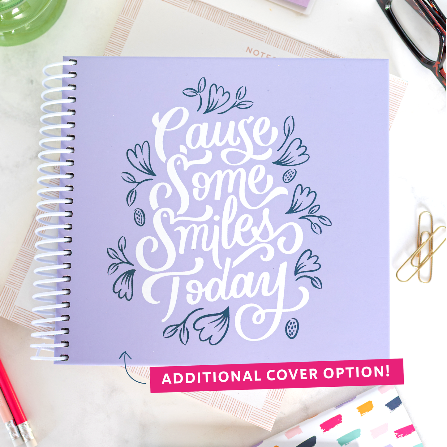 Additional lavender cover option with 'Cause Some Smiles Today' design on a desk with stationery items.