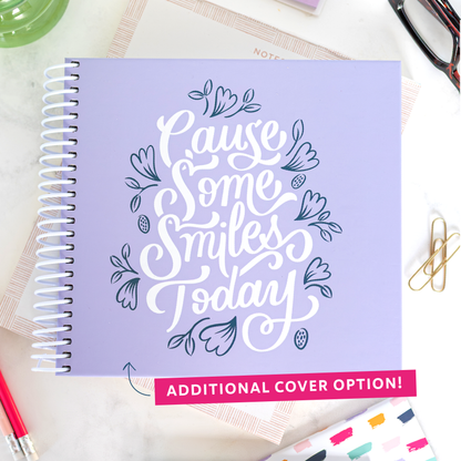 Additional lavender cover option with 'Cause Some Smiles Today' design on a desk with stationery items.