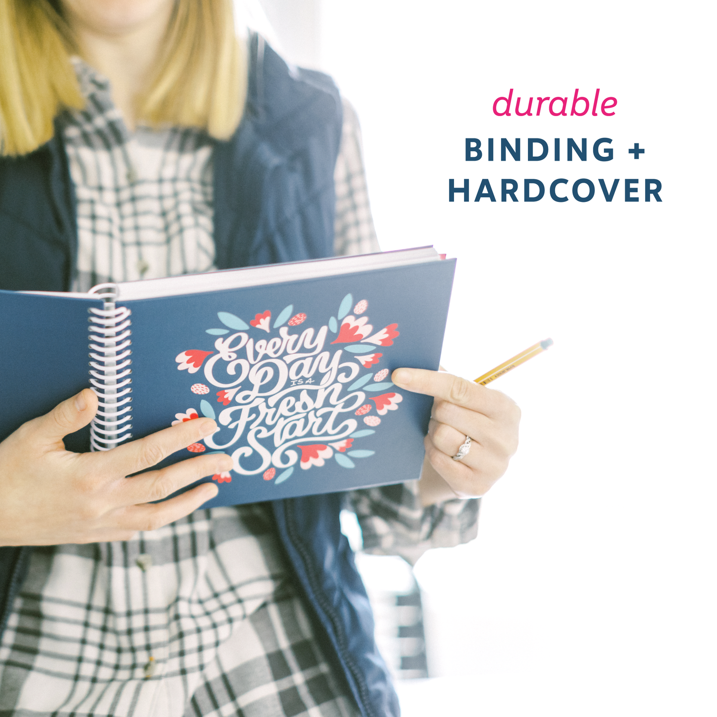 Person holding the navy planner, showcasing the durable binding and hardcover