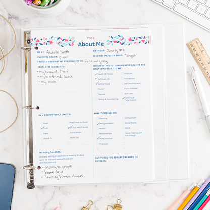 Personal information sheet titled 'About Me' in a binder on a desk with stationery items.