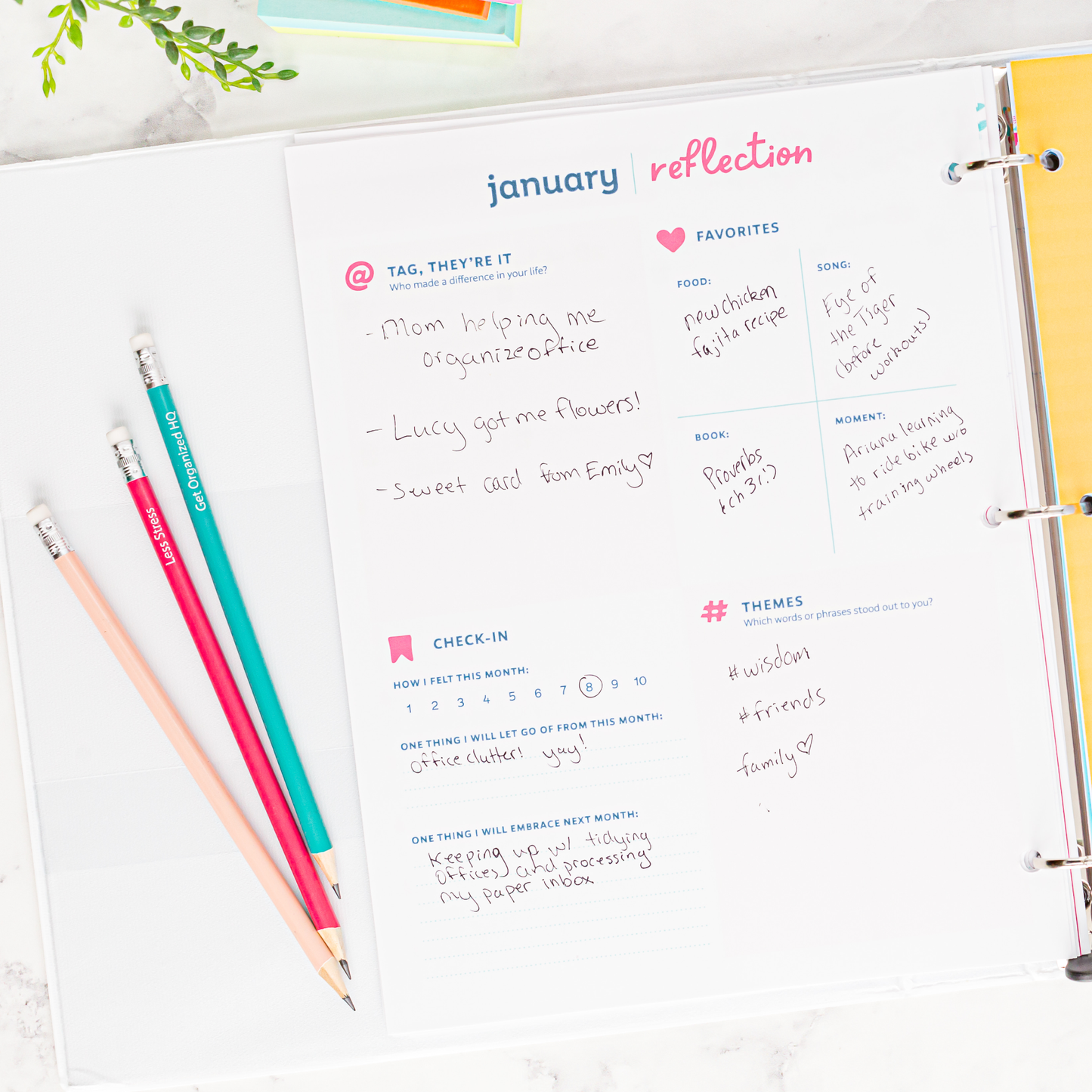 January reflection page in a planner with colored pencils on a white surface