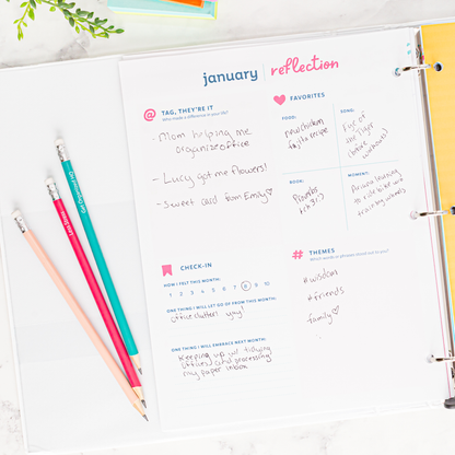 January reflection page in a planner with colored pencils on a white surface