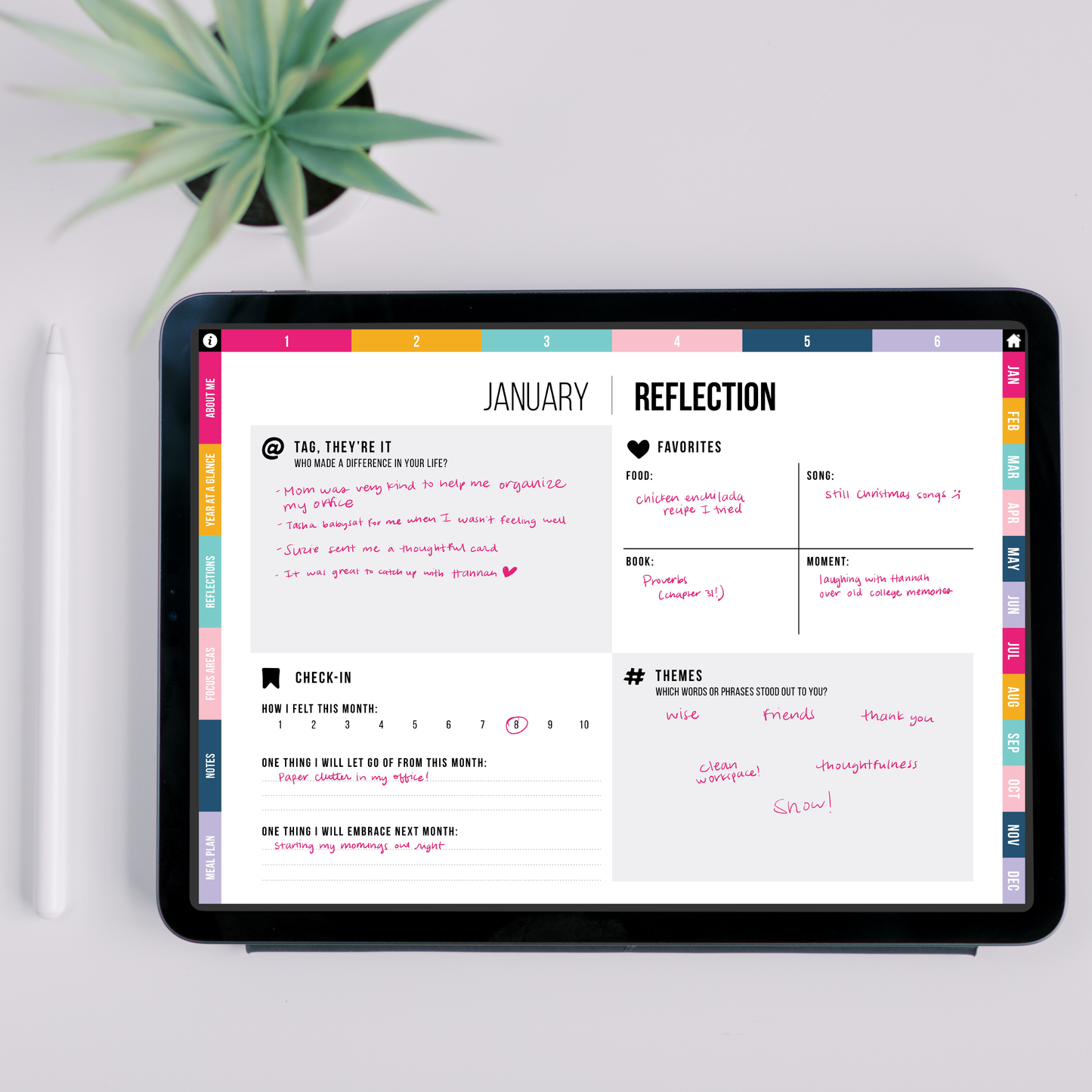 Monthly reflection page on a tablet with a plant in the background
